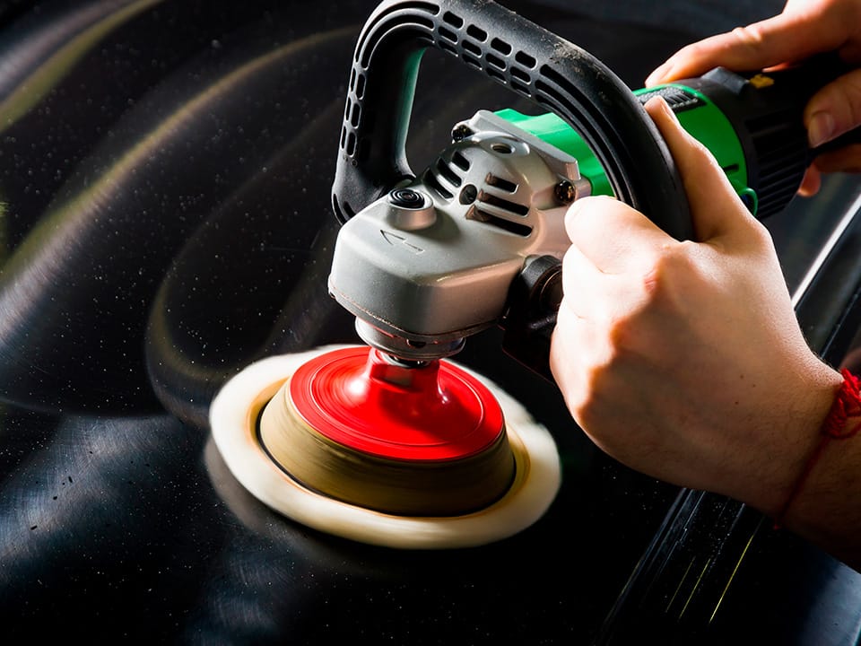 Applicazione della pasta abrasiva per auto nera con la lucidatrice per un risultato professionale